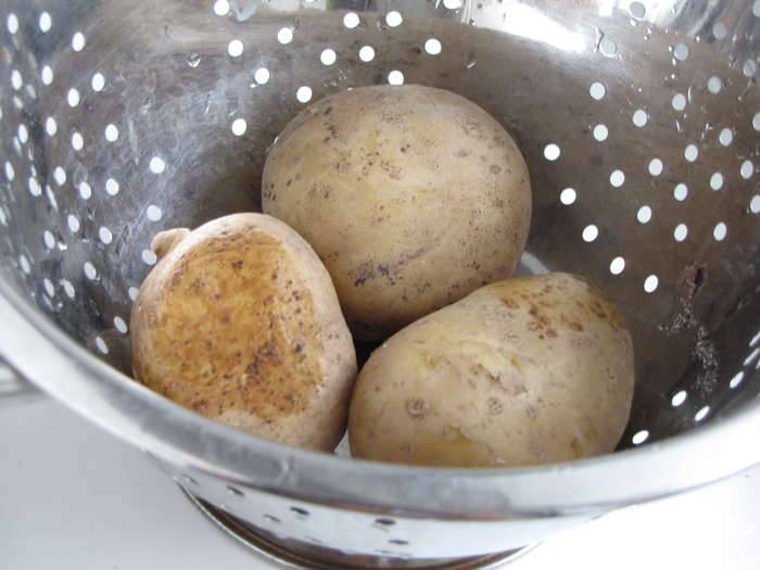 Сперва хорошо вымойте картофель, отварите его в мундирах. Обычно такой картофель нужно варить 25 минут. Когда он остынет, очистите его от кожуры. Картофель нарежьте небольшими кусочками. Морковь натрите на крупной тёрке. Так же натрите сыр. 