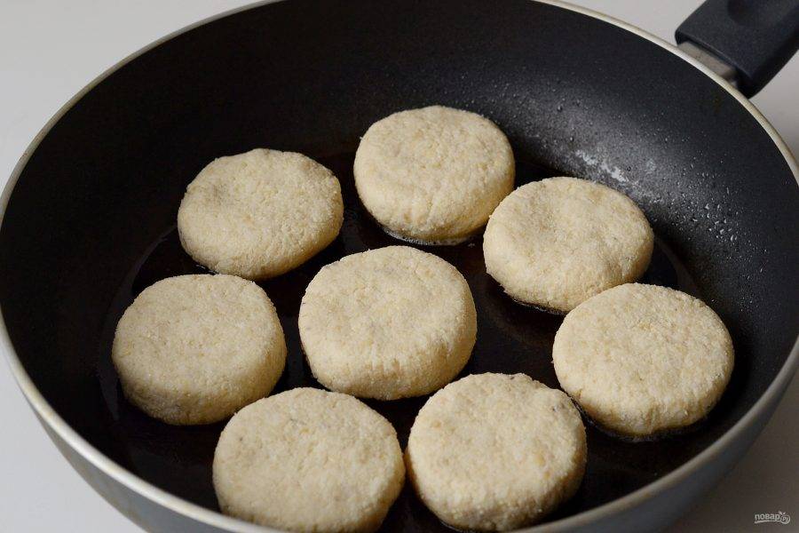 Разогрейте сковороду с маслом на среднем огне. Выложите сырники. Накройте сковороду крышкой и жарьте 3-5 минут. Переверните сырники и жарьте вторую сторону еще 3-5 минут.
