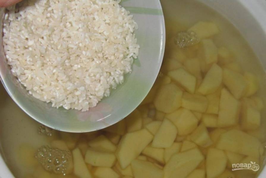 Когда вода закипит, добавьте в неё картофель и промытый рис.