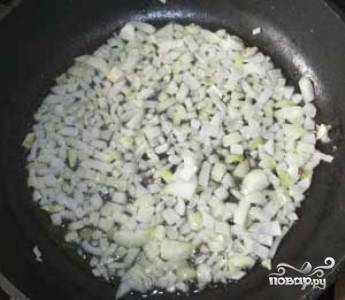 На горячую сковороду налейте растительное масло. Когда масло нагреется, выложите на сковороду мелко нашинкованный лук и жарьте до тех пор, пока лук не станет прозрачным.