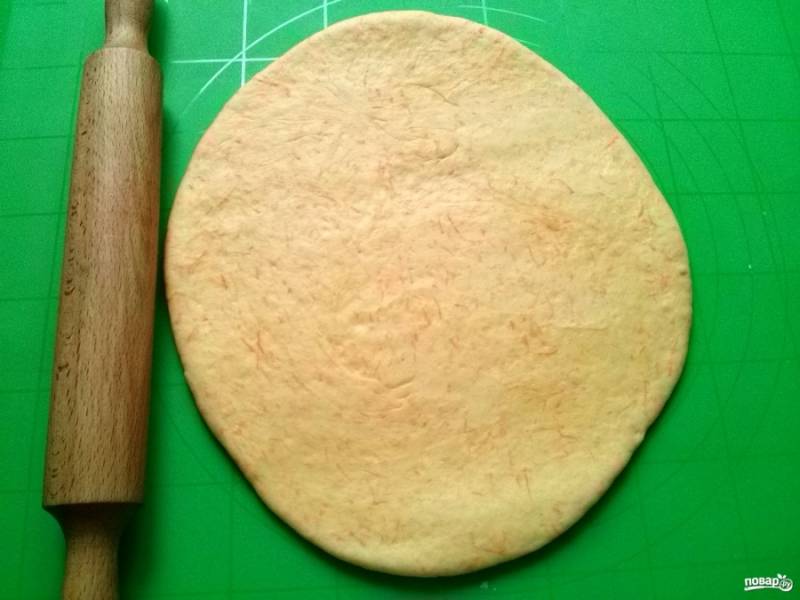 Разделите тесто на две равные части. Раскатайте одну в овальную лепешку толщиной 0,5см. 
