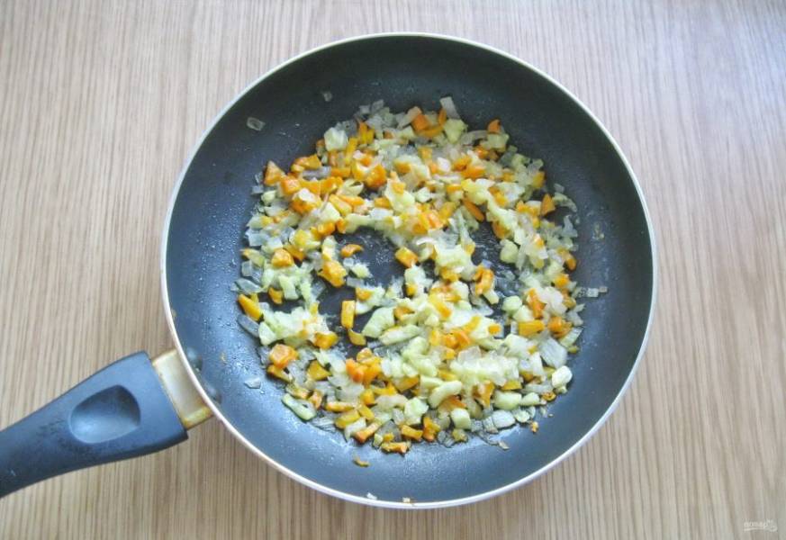Репчатый лук и морковь очистите и помойте, мелко нарежьте и выложите в сковороду с подсолнечным маслом. Мякоть, которую вы достали из кабачка мелко нарежьте и добавьте в сковороду к луку и моркови. Только не всю, а 100-150 грамм. Тушите эти овощи на среднем огне, перемешивая 10-12 минут.