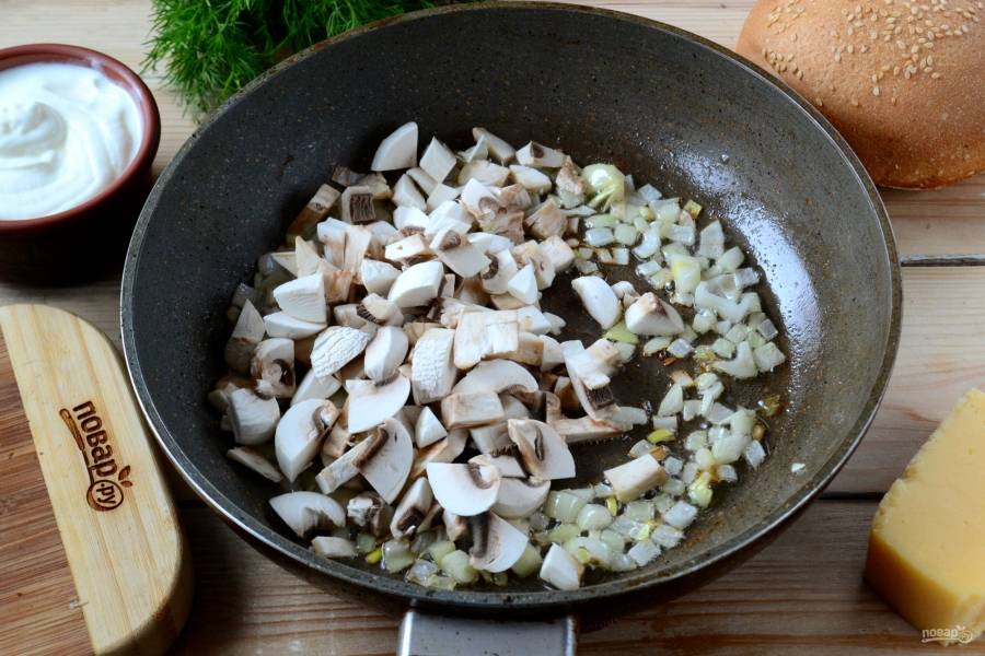 Выложите грибы вместе с луком в сковороду, добавьте немного растительного масла. Жарьте. Жидкость, выделившаяся из грибов, не испарится.