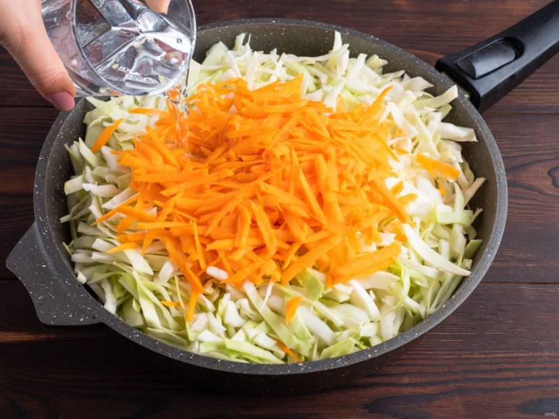 Капусту нашинкуйте не очень мелко, морковь натрите на крупной терке. Выложите овощи в сковороду и залейте водой. Тушите на медленном огне под крышкой, периодически помешивайте. Тушите до полного выпаривания воды.