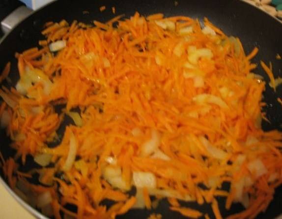 Наливаем в сковородку масло и разогреваем ее. Обжариваем сначала морковь около 5 минут, постоянно перемешивая, затем добавляем лук. Жарим до появления золотистого оттенка. 