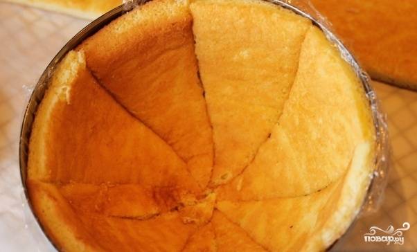 Возьмите салатник, выложите разрезанный бисквит острыми концами к центру, как показано на фото. После приготовьте кофе объёмом 100 мл. Остудите и добавьте ликёр. Смешайте, пропитайте им бисквит.