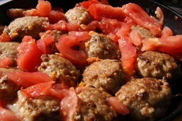 Туда же добавьте мелко порезанные или пропущенные через мясорубку помидоры. Если жидкости мало, долейте воды так, чтобы ежики были на две трети в подливе. Посолите и протушите 20 минут под крышкой.