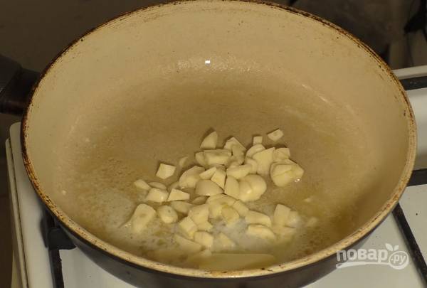 1. В сотейник или кастрюлю выложите сливочное масло. Добавьте нарезанный чеснок, обжарьте пару минут, помешивая. 