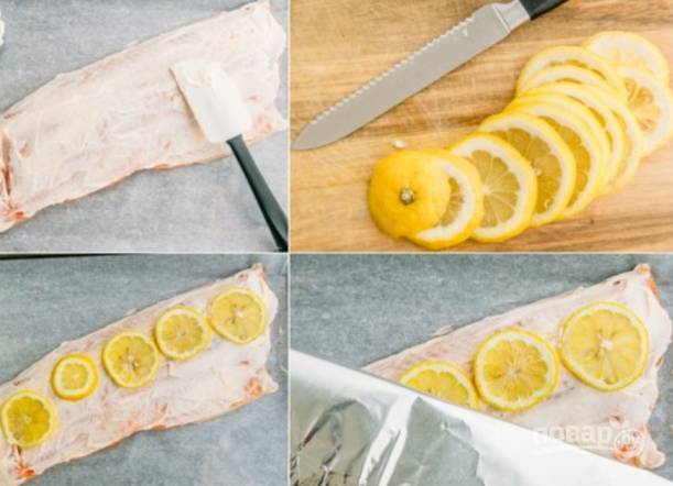 Теперь хорошенько смажьте рыбу майонезом, уложите на нее дольки лимона. Духовку разогрейте до 180 градусов.