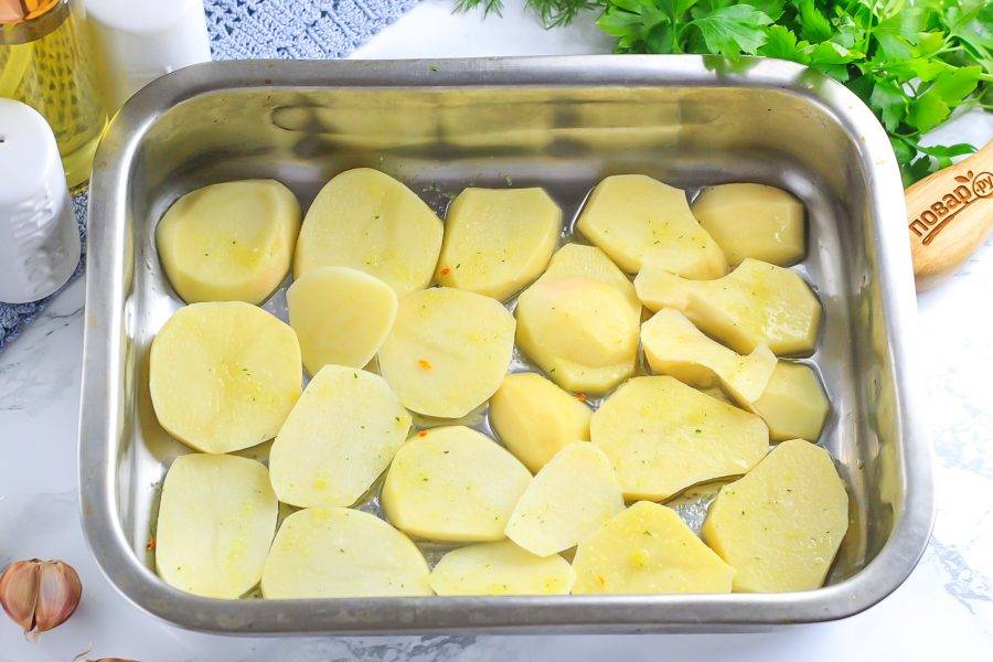 Картофель нарежьте ломтиками. Смажьте форму растительным маслом и выложите в нее ломтики картофеля. Присыпьте их приправой для рыбы.