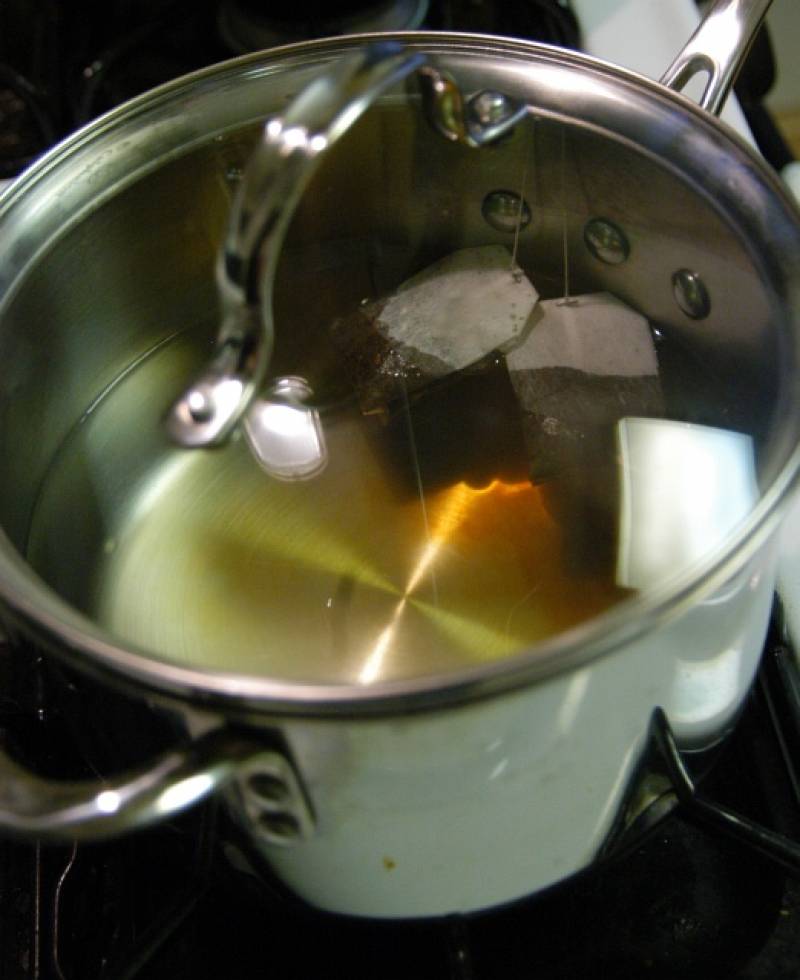 Бросьте две чайные пакетики в воду и снимите с огня. Накройте крышкой и дайте чаю постоять минимум на 1 час.  