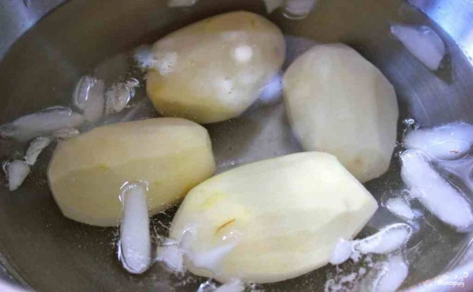 2. Очистите вымытый картофель и опустите в очень холодную воду. Можно добавить несколько кусочков льда, например. Это позволит картошке оставаться хрустящей. 