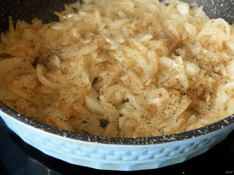 Параллельно обжарьте в сковороде до позолоты нашинкованный полукольцами лук (на оставшемся масле), слегка посолив и щедро поперчив его в процессе приготовления.