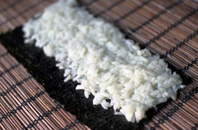 На лист нори выложите слой риса. 