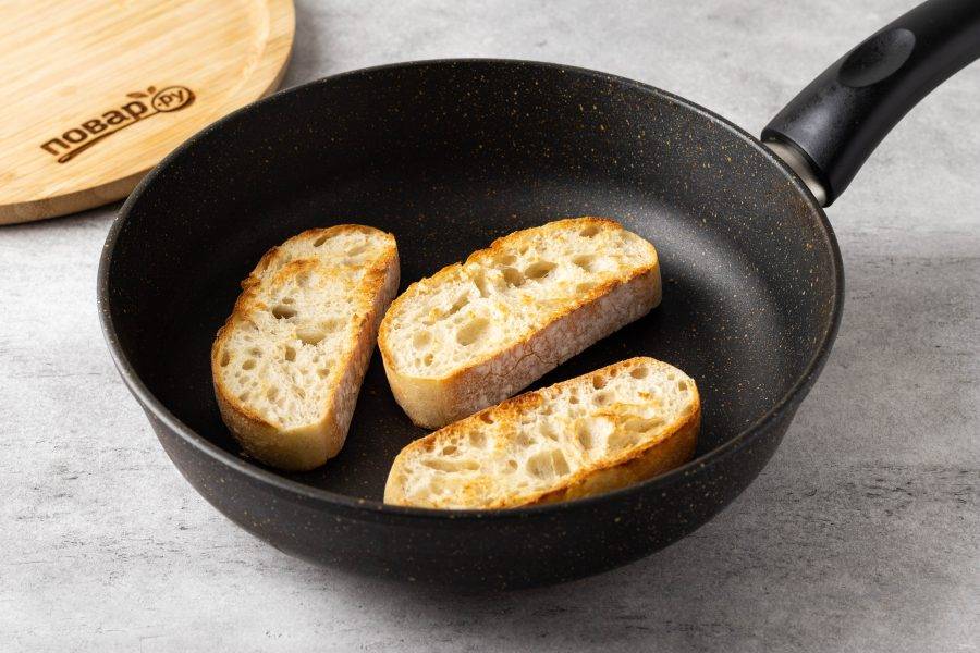 Нарежьте хлеб на ломтики и подсушите в сковороде с двух сторон.