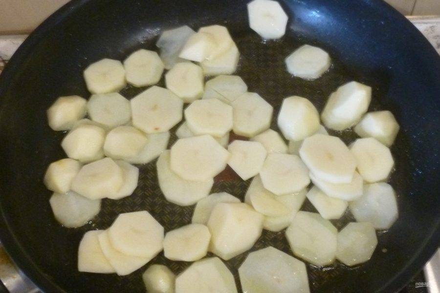 Картофель, баклажаны и кабачок нарежьте кружочками, перец - полосками. Картофель обжарьте в течение 5-10 минут на небольшом количестве масла.
