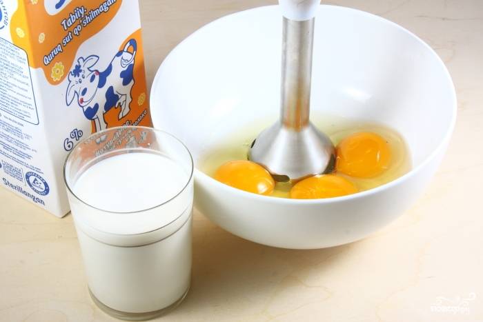 Приготовьте заливку. В миску вбейте яйца, добавьте молоко и соль. Взбейте смесь блендером до пены.