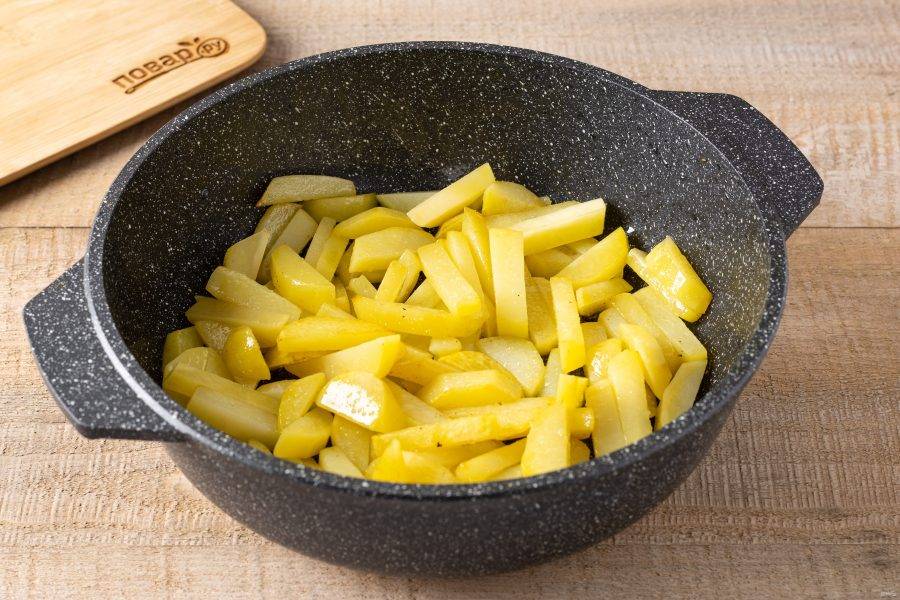 Разогрейте сковороду с растительным маслом и обжарьте картофель до полуготовности.