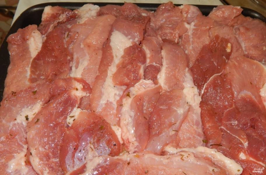 4.	Следующим слоем выкладываем кусочки свинины из расчета, что они в один слой покроют картошку с луком, солим и перчим.