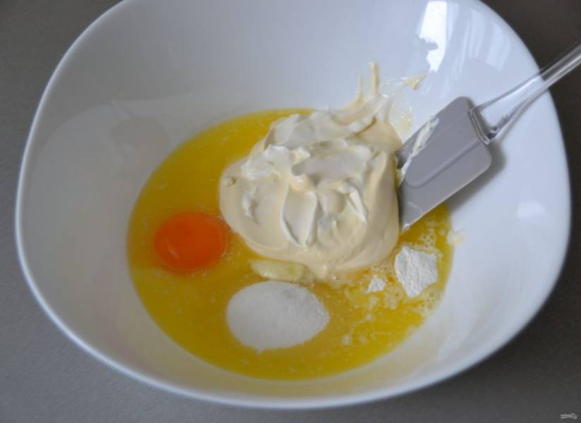 Растопите сливочное масло, добавьте в него яичный желток (белок оставьте для приготовления меренги), 2 ст. ложки сахара, щепотку соли, сметану и разрыхлитель, смешайте.