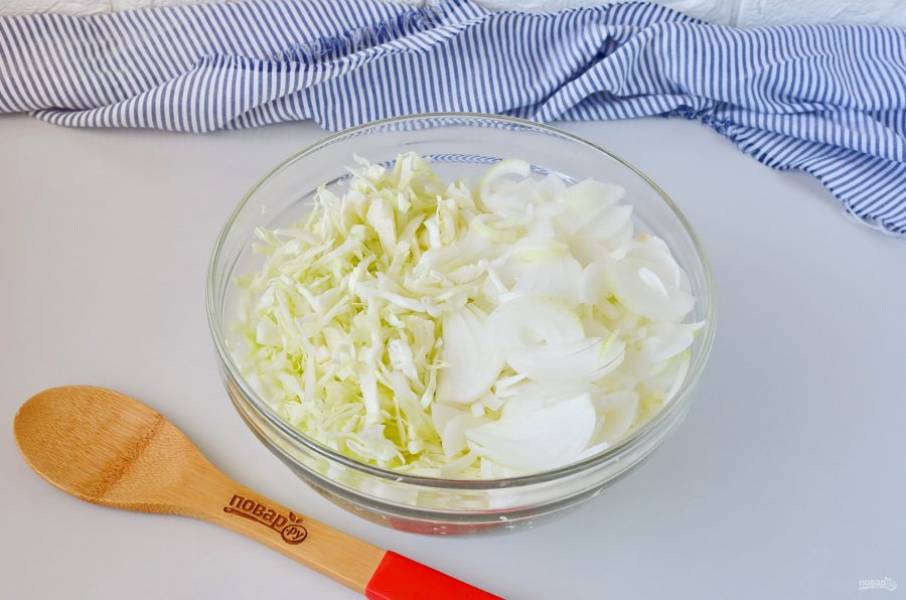 Тем временем нашинкуйте капусту, порежьте тонкими полукольцами лук. Выложите овощи в большую удобную миску или кастрюлю.