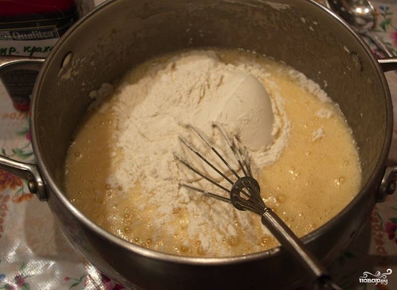 Самое главное в этом рецепте - правильно приготовить крем. Для этого возьмите большую кастрюлю, смешайте в ней яйца и сливочное масло с сахаром. Затем туда же положите муку и крахмал, хорошо перемешайте. 