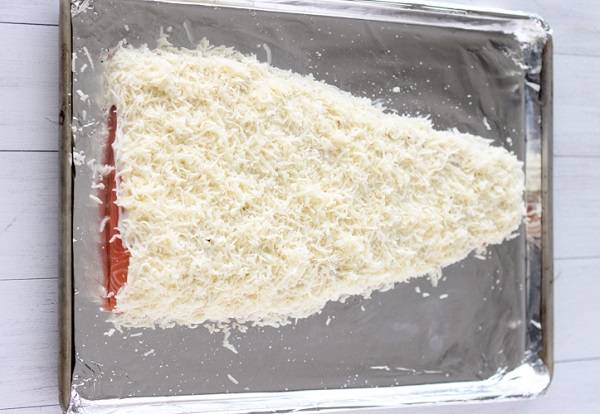 5. Натереть сыр на мелкой или средней терке. Можно соединить два вида сыра - моцареллу и пармезан, например. Присыпать сыром сверху. Теперь запеченная семга с сыром в домашних условиях может отправляться в разогретую духовку. 