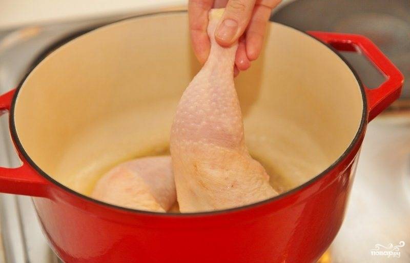 В кастрюле с толстым дном, где будем варить суп, растапливаем сливочное масло и обжариваем в нем куриные ножки (целиком). 