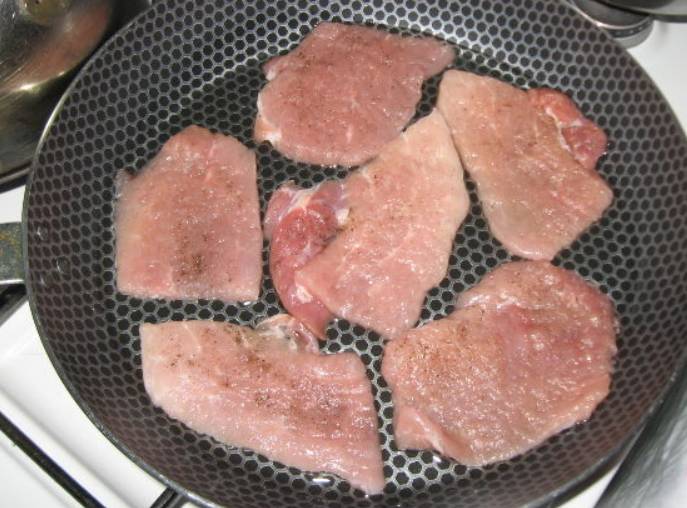 Свинину нарезаем порционными кусочками, каждый из которых слегка отбиваем и выкладываем в форму для запекания. Солим и перчим по вкусу.