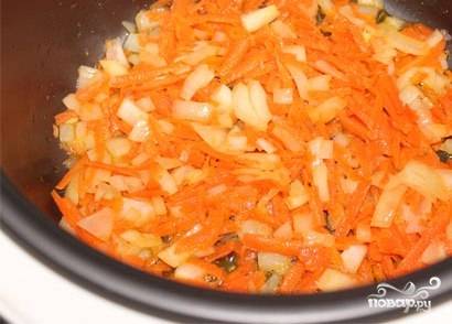 В чашу мультиварки налейте растительное масло и выложите мелко нашинкованный лук и натертую на крупной терке морковь. Жарьте 10 минут в режиме "Выпечка".