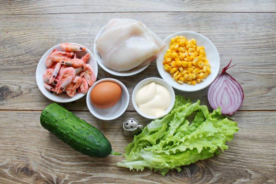 Подготовьте все необходимые ингредиенты для приготовления салата с кальмарами, креветками и кукурузой. Овощи и зелень вымойте и обсушите.