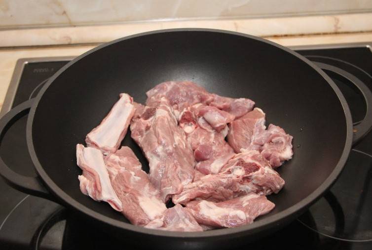 Начнем с того, что очень тщательно промоем баранину и нарежем ее на порционные кусочки, выкладываем половину мяса на дно кастрюли.