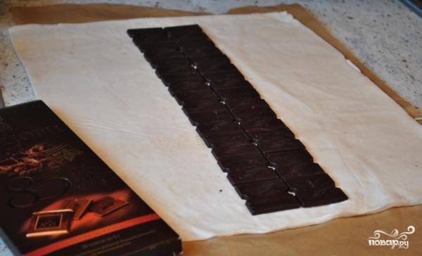 Выкладываем посередине раскатанного листа теста плитку шоколада.