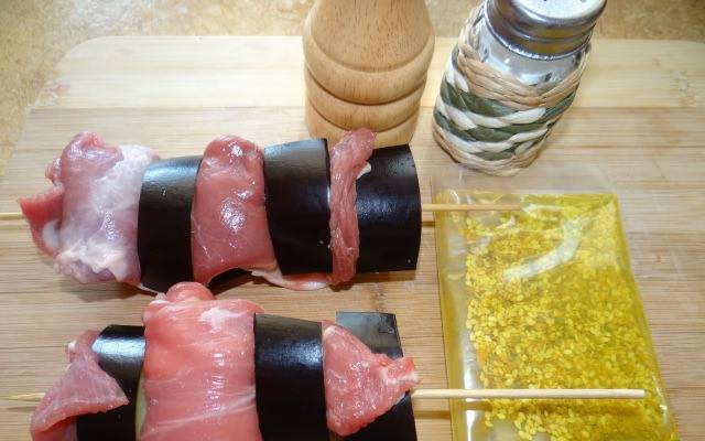 1. Подготовим ингредиенты. Мясо натираем солью и специями. Баклажан режем кружочками, и нанизываем на шпажку. А куски мяса как бы накручиваем по спирали на палочку.
