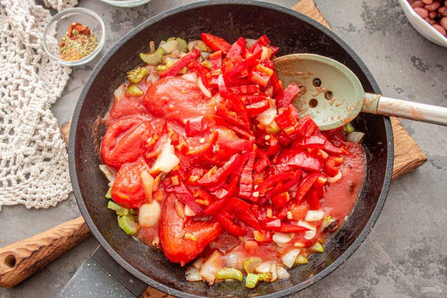 Добавьте в сковороду к овощам консервированные томаты. 
