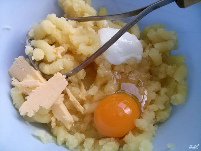 Картофель немного остудите, очистите и  растолките в пюре. Добавьте яйцо, сметану, сливочное масло и соль по вкусу. Пюре не должно быть очень густым.