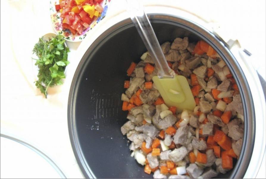 Через 30 минут, с момента когда начали готовить мяса, добавляем в чашу мультиварки лук и морковь. Обжариваем с мясом 10 минут.