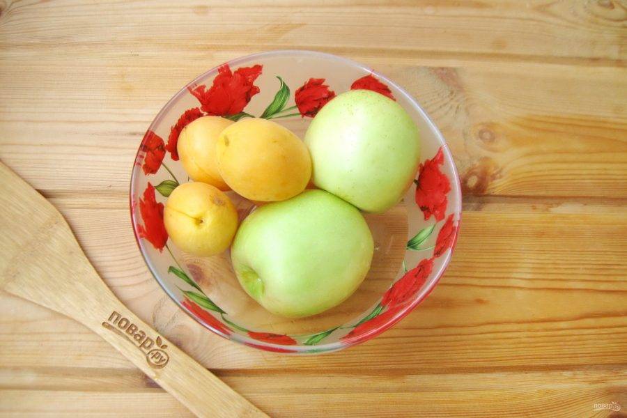 Тщательно вымойте фрукты. У яблок удалите плодоножку и сердцевину. Нарежьте дольками. Абрикосы разрежьте на половинки и удалите косточку.