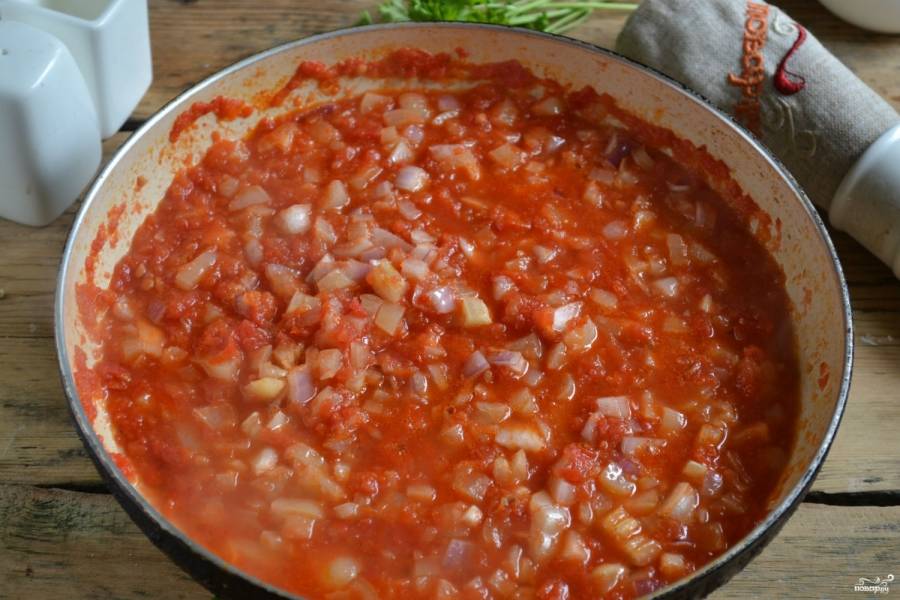 В большую кастрюлю или сковороду вылейте томатное пюре, добавьте соль и сахар. Прокипятите 10 минут. Затем положите мелко нарубленный чеснок. Потом добавьте порезанный лук и болгарский перец и варите 20 минут, периодически помешивая.