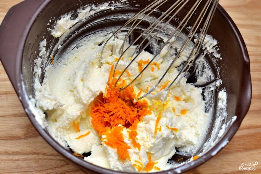 Когда корж уже почти готов, сделайте крем. Для этого смешайте в чашке сыр Маскарпоне, топлёное масло и цедру апельсина.