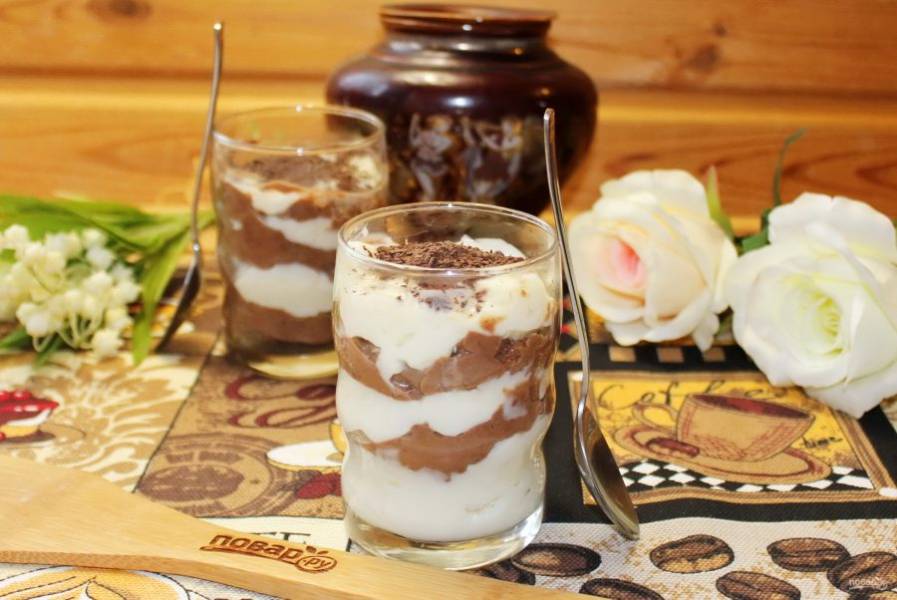 Выложите десерт в стаканы, чередуя светлый крем с темным. Сверху посыпьте тертым шоколадом. Можно подавать к столу.