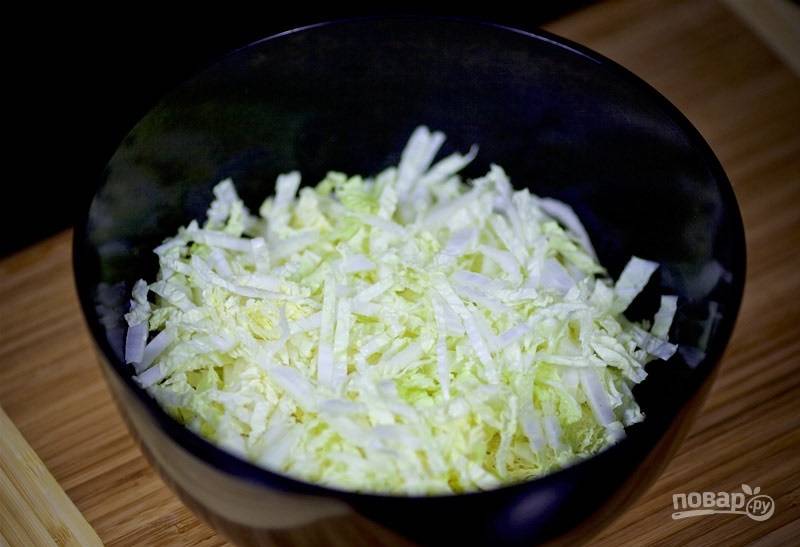 2. Нашинкуйте капусту, выложите её в глубокий салатник. 