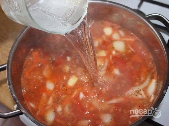 Фасоль варилась в небольшой кастрюле, поэтому перекладываю её в кастрюлю побольше. Добавляем помидоры, лук, чеснок и примерно 0,5 литра горячей воды. Варим около 45-50 минут на небольшом огне.