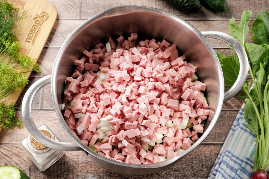 Добавьте сюда же нарезанную кубиками колбасу.