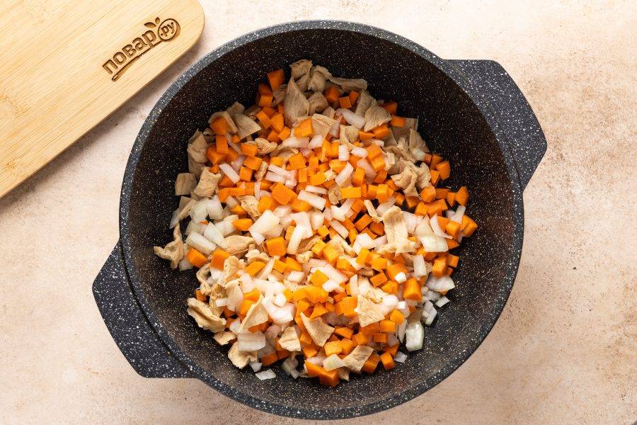 В разогретом растительном масле обжарьте репчатый лук, соевое мясо и морковь. Жарьте до мягкости овощей, примерно 10 минут.