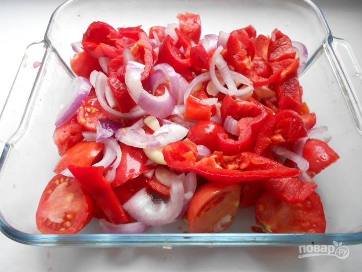 Нарежьте помидоры, лук и перец. Уложите их в огнеупорную форму. Сверху присыпьте измельчённым чесноком и солью. Добавьте масло и перемешайте.