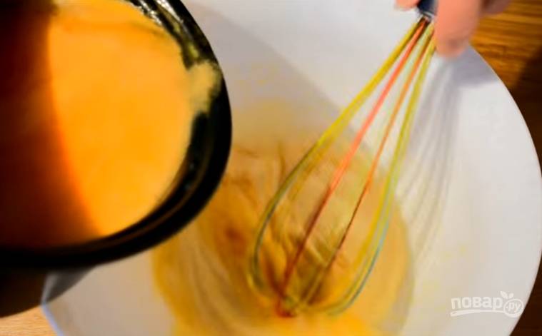 7. Для крема: в миску вбейте яйца, к ним добавьте сахар и крахмал, перемешайте. Сок перелейте в сотейник и отправьте на огонь, доведите до кипения, а затем тонкой струйкой влейте к яйцам. 