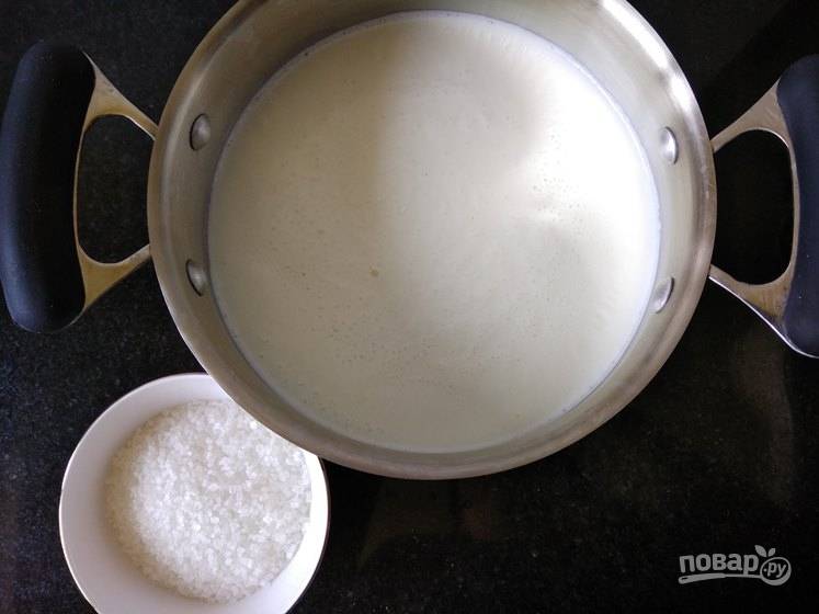 2. Молоко соедините с сахаром в кастрюльке и поставьте на огонь. После закипания уберите огонь до минимума и томите, пока молоко не уварится примерно в половину. 