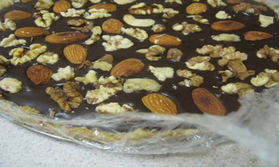 5. Выливаем шоколадную смесь поверх коржа и посыпаем щедро орешками. Можно оставить в холодильнике, а можно подавать с еще теплой шоколадной прослойкой!