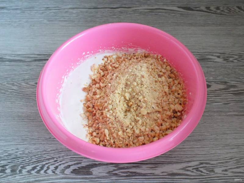 К взбитым белкам добавьте смесь орехов и крошки из теста. Перемешайте ложкой.